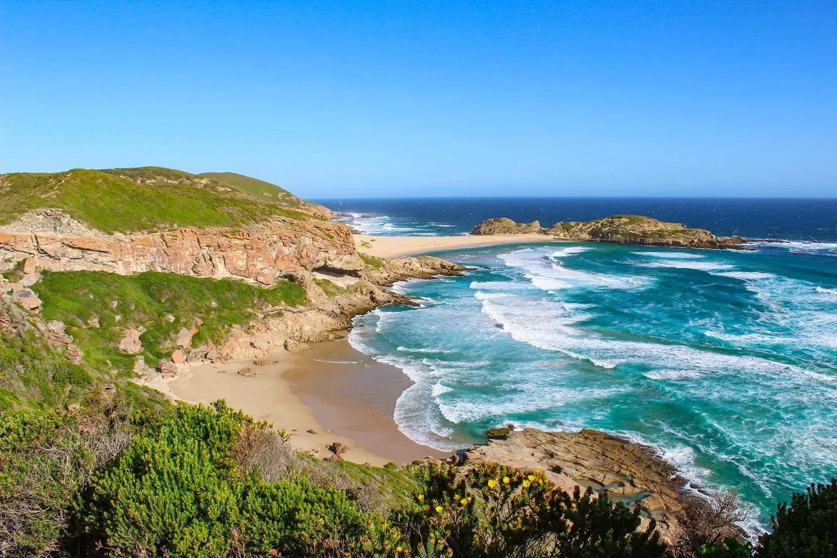 Rocky coastline and a sandy cove at the Robberg headland near Plettenberg Bay on the Garden Route, South Africa