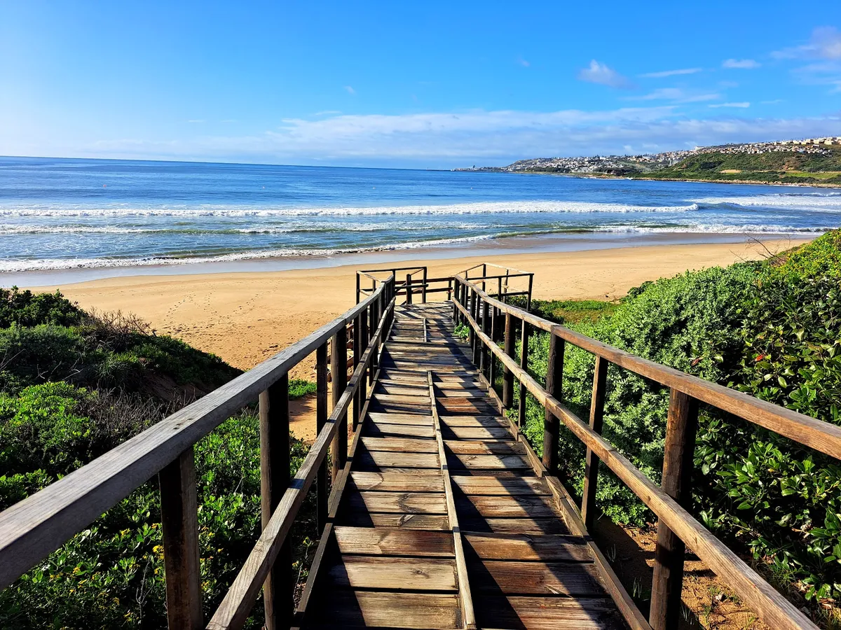 Timber boardwalk leading down through dune vegetation to the sand at Diaz Beach, Mossel Bay