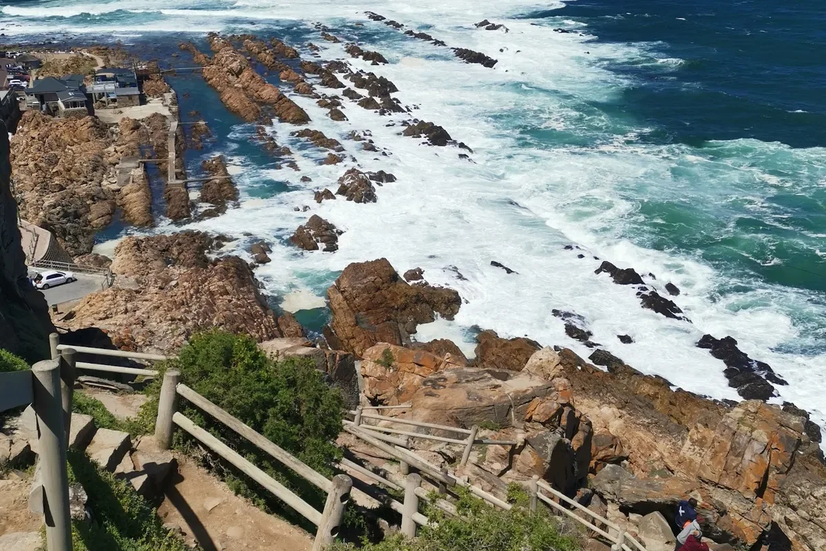 Rocky Indian Ocean shoreline at Mossel Bay's Point, with a boardwalk and steps down to the rocks and breaking waves