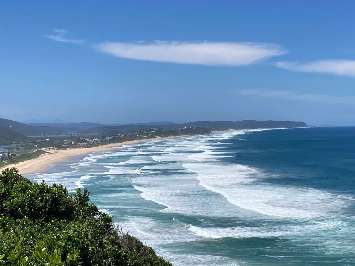 The long curve of Wilderness beach seen from Dolphin Point, with the village and Outeniqua Mountains behind